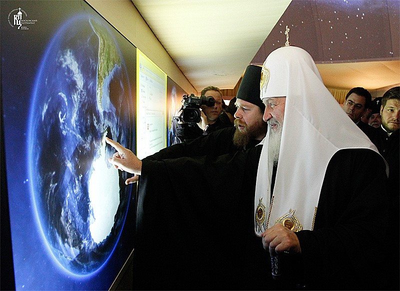 Патриарх у интерактивного глобуса на выставке