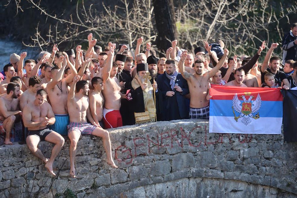 Metropolitan Amfilohije with participants in the swim in the Morac River. 