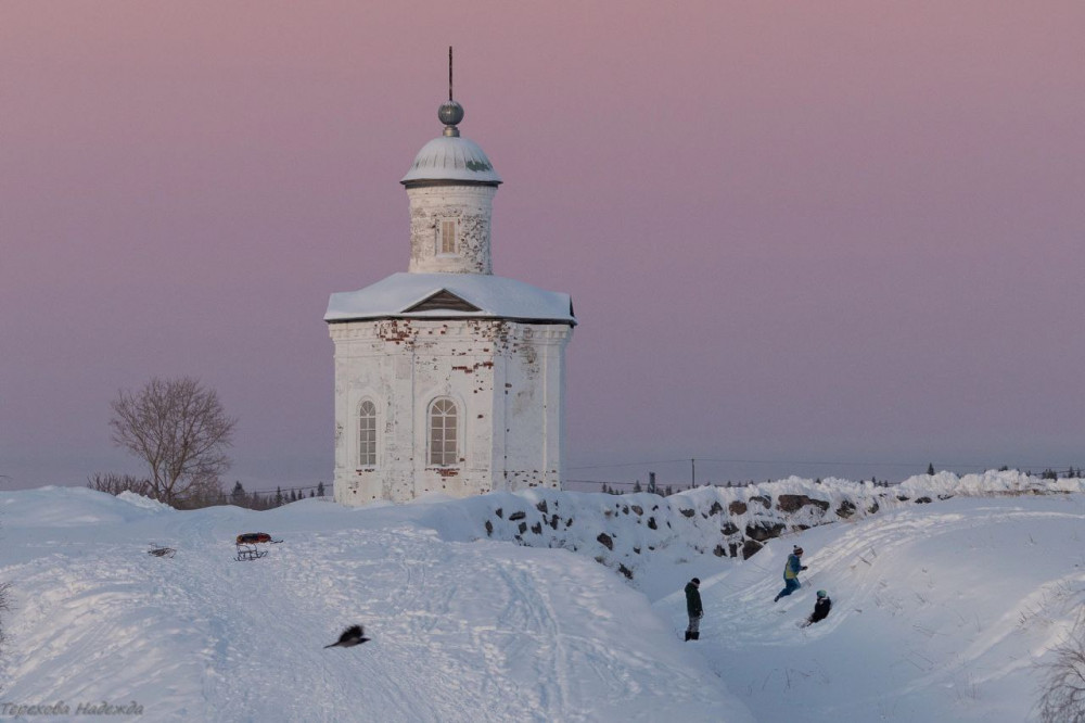 The Chapel of Sts. Constantine and Elena. Children sledding down the hill and playing in the snow