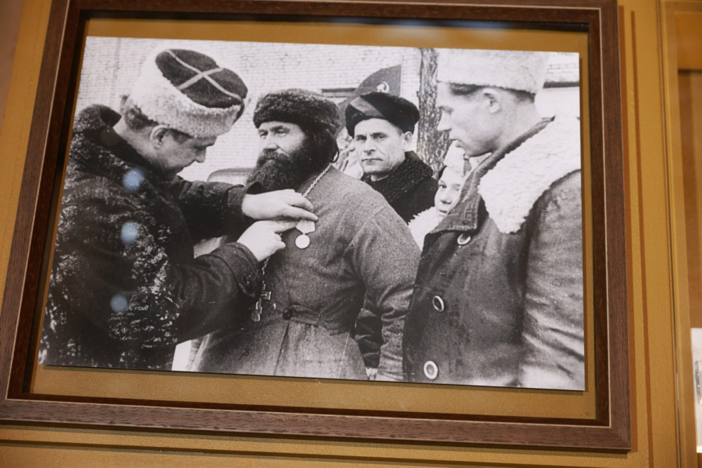 Командир 5-й Ленинградской партизанской бригады, Герой Советского Союза К.Д. Карицкий прикрепляет медаль «Партизану Отечественной войны II степени» священнику церкви псковского села Хохловы Горки Порховского района Федору Пузанову (1888-1965)