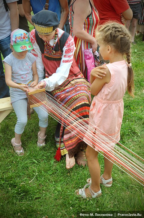 Маленьких гостей фестиваля учат ткать пояс на бердо